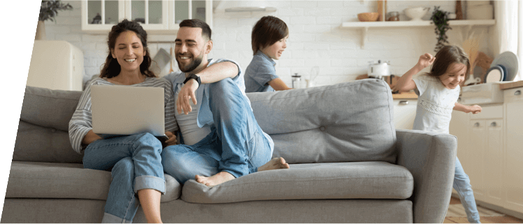 Young family of four gathered in the living room