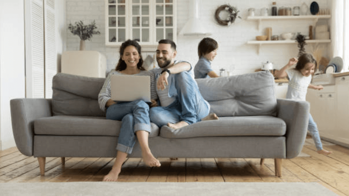 Young family of four gathered in the living room