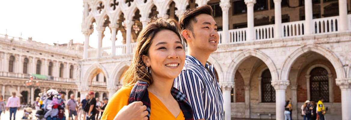 Two tourists walking in a bustling square