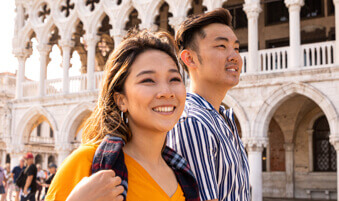 Two tourists walking in a bustling square