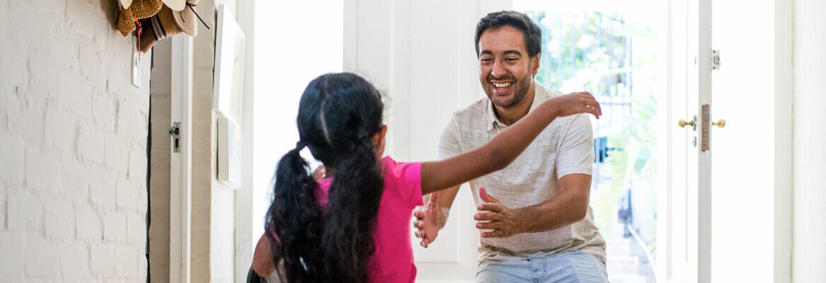 Father hugging daughter in home entryway