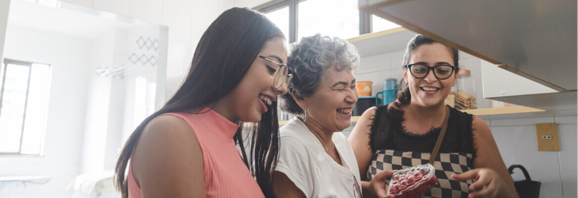 Grandmother, mother, and daughter cooking in kitchen