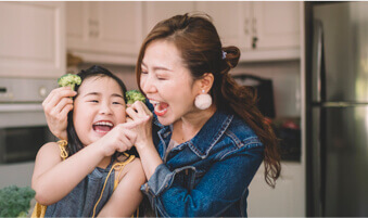 Mother and daughter laughing in the kitchen