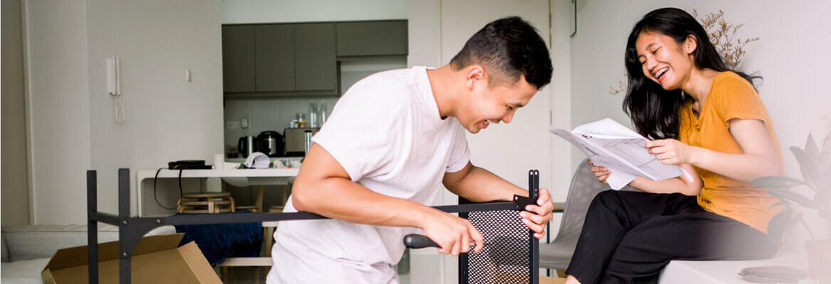 Smiling couple assembling furniture in living room