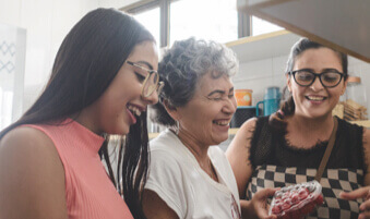 Grandmother, mother, and daughter cooking in kitchen